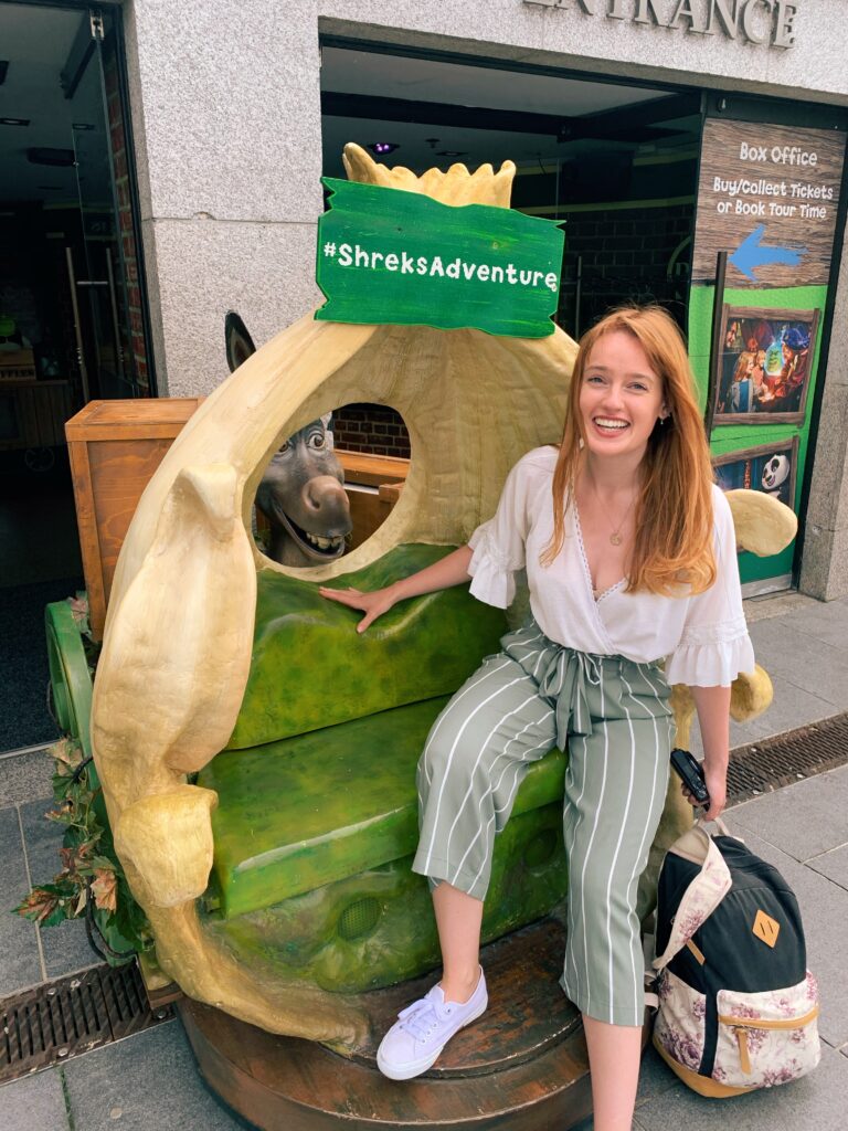 Travel blogger sat outside the Shrek museum on Southbank in London