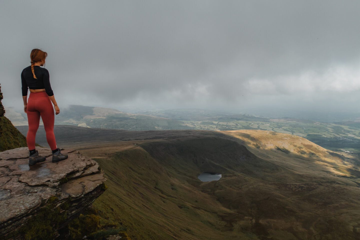 girl stood on an overhanging ledge in the Brecon Beacons